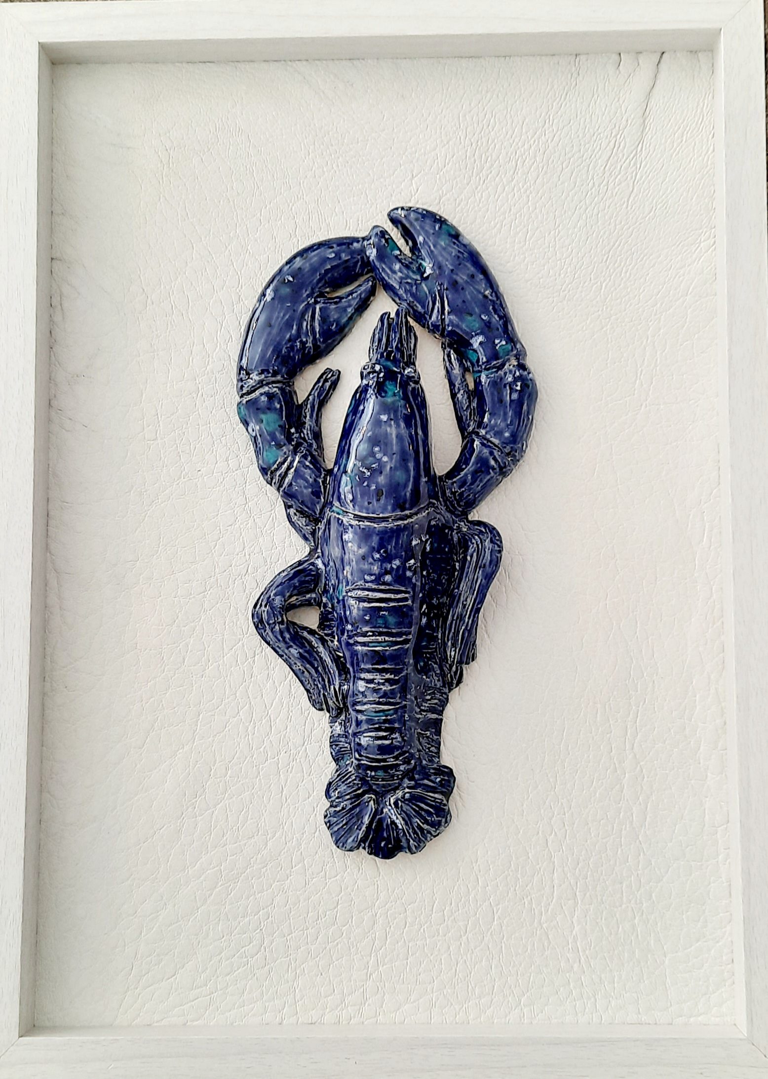 Homard décoratif en céramique bleu foncé présenté dans un cadre