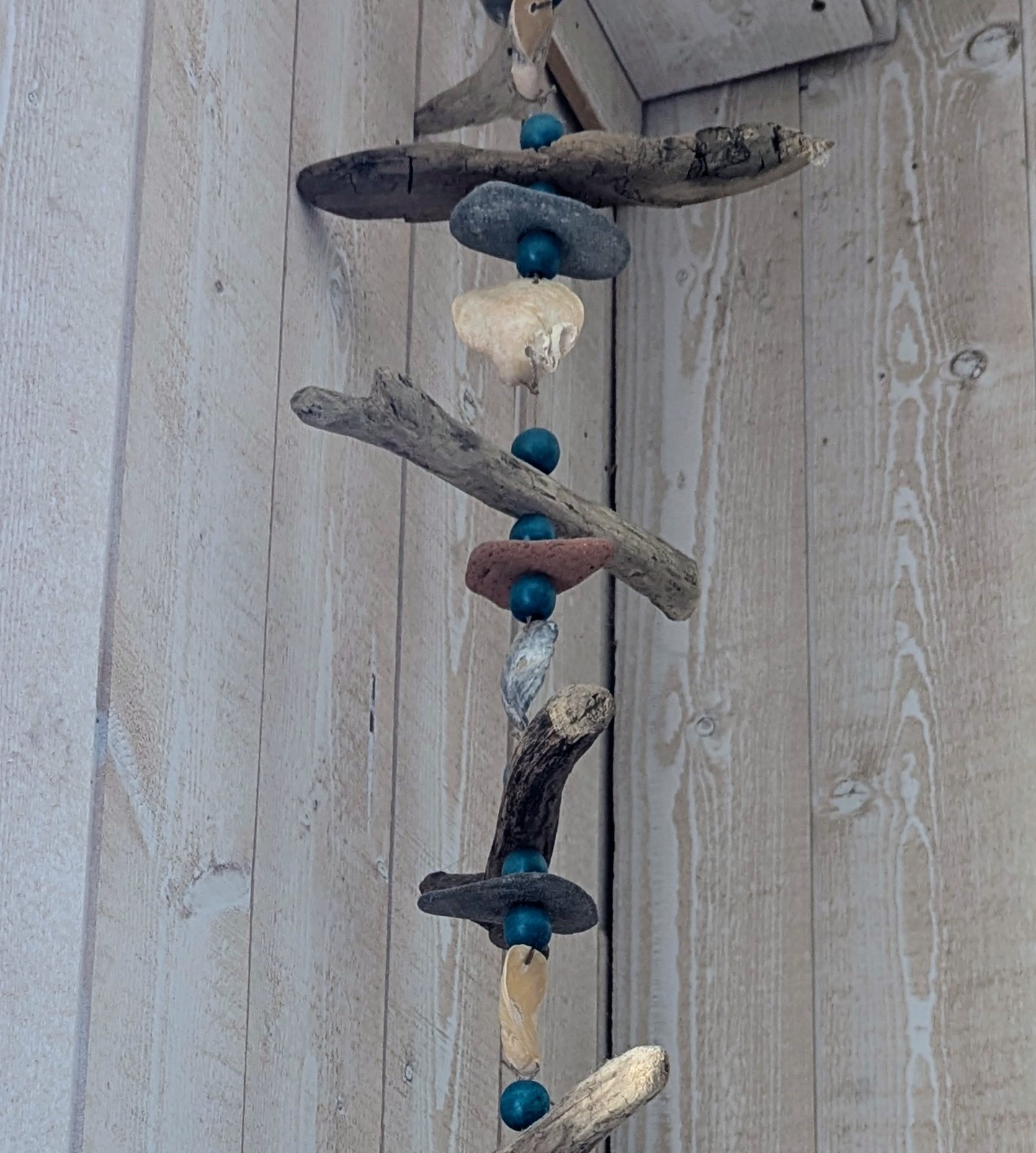 Suspension décorative en bois flotté avec coquillages et galets